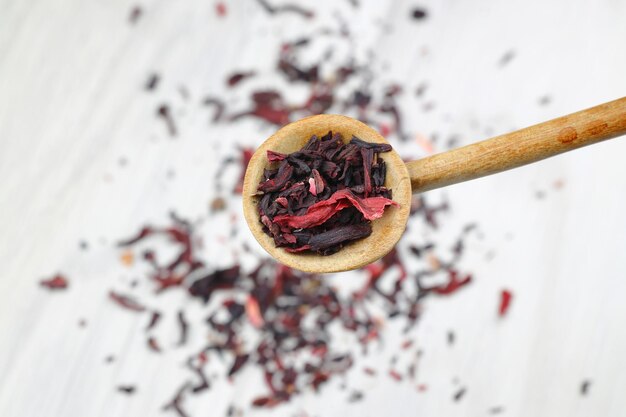 Foto chá karkade folhas de chá de hibisco em colher de madeira isoladas em fundo branco o arquivo contém o caminho de recorte