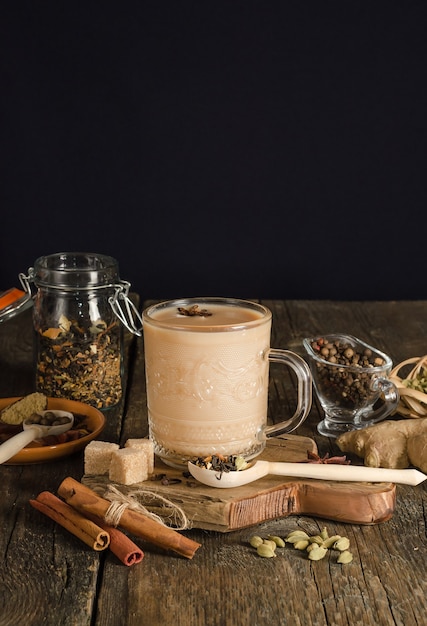 Chá masala com especiarias em fundo preto com espaço de cópia, bebida de aquecimento da índia