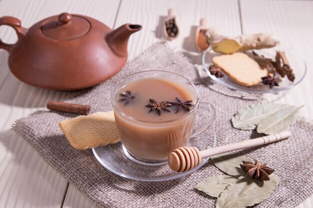 Chá Masala Índia chá revigorante com leite e especiarias em um fundo branco com um guardanapo