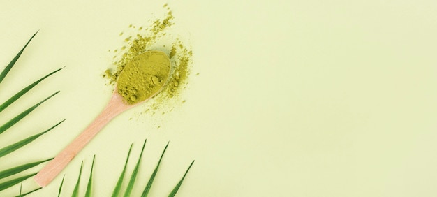 chá matcha com colher e folha sobre fundo verde
