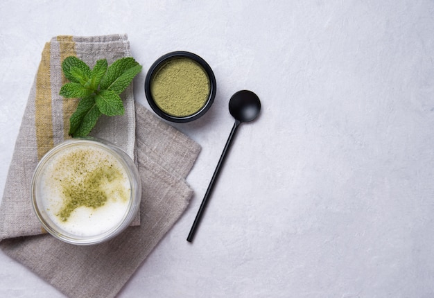 Chá matcha verde em vidro transparente no fundo branco