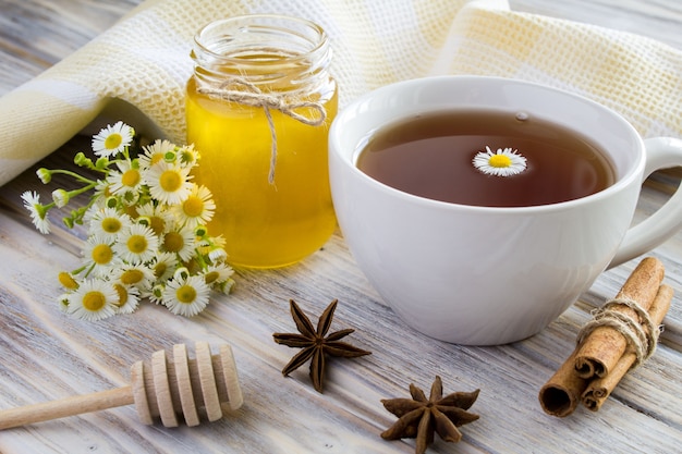 Chá, mel, canela e camomilas em madeira