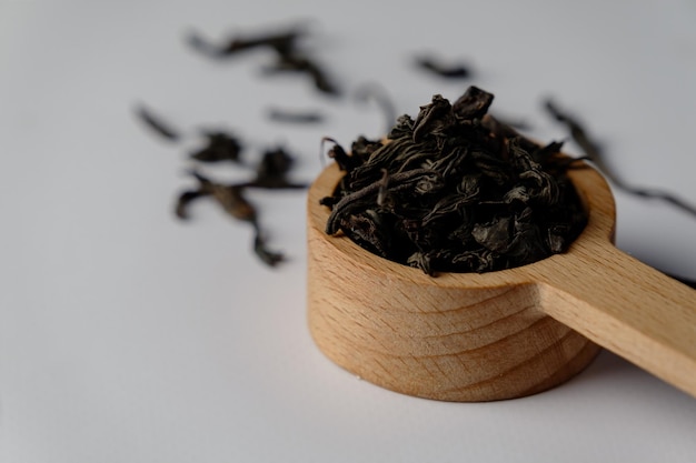 Chá preto em uma colher em um fundo branco. O Close-up. foto de alta qualidade