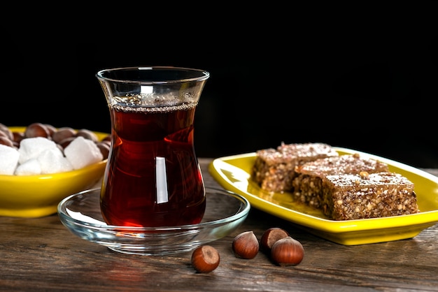 Chá preto perfumado em um copo e com Shaki halva