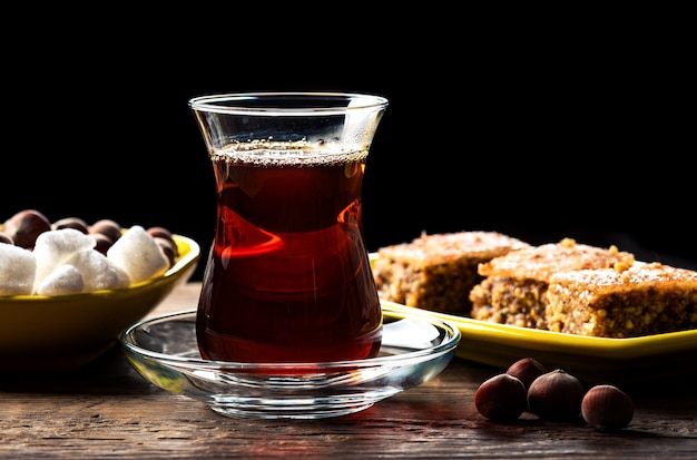 Chá preto perfumado em um copo e com Shaki halva