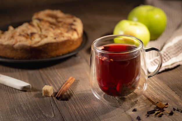 Chá quente de hibisco em copo de vidro duplo e bolo de maçã caseiro, café da manhã outonal natureza morta, foco seletivo