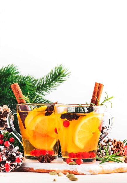 Chá quente de inverno com ervas e especiarias de cranberries de limão na mesa de Natal ou Ano Novo definindo espaço de cópia de fundo branco