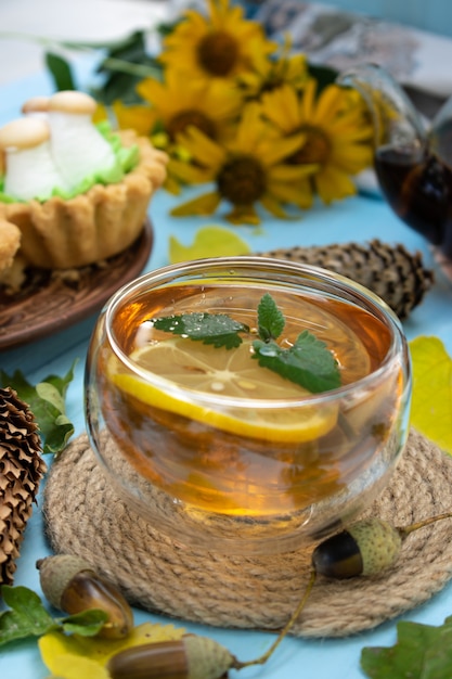 Chá quente de limão e biscoitos com cobertura de creme em uma mesa de madeira com foco seletivo