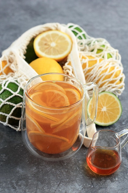 Chá quente de limão e mel em vidro transparente acima da mesa de cimento
