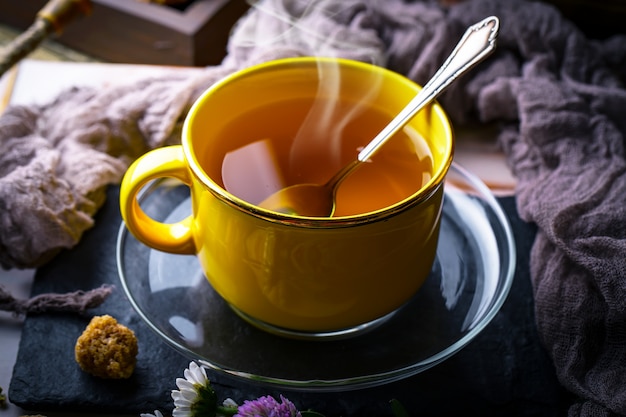 Chá quente em uma xícara em uma mesa velha.