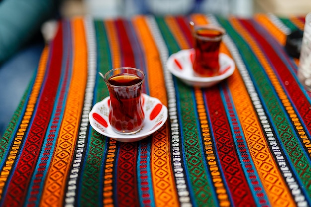 Chá turco tradicional que é bebido perto de um café na rua do mercado de Istambul