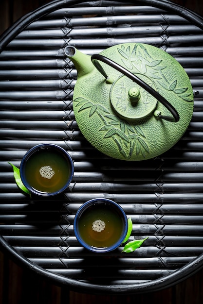 Chá verde aromático na mesa de bambu preto