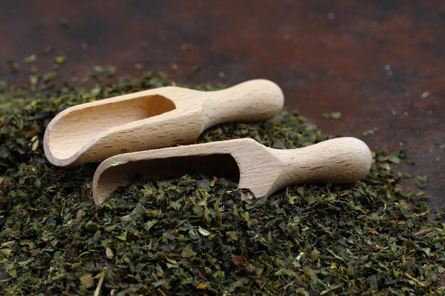 Foto chá verde com ervas em colheres de madeira em uma tábua de madeira