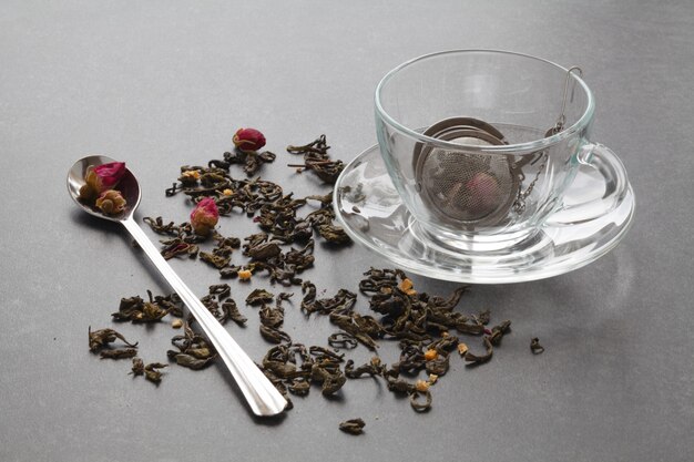 Chá verde derramado com uma rosa na mesa de pedra