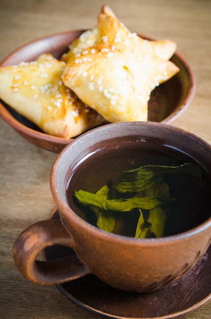 Chá verde e tortas na mesa de madeira rústica