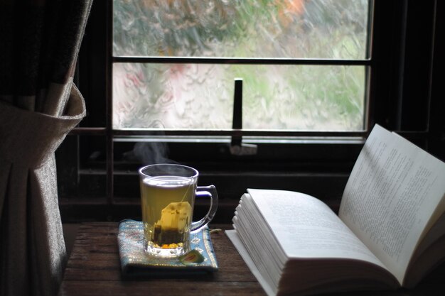 Foto chá verde em xícara por livro aberto na mesa