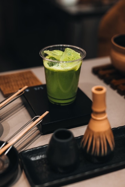 Chá verde Matcha em um copo de plástico Natureza morta com acessórios tradicionais orgânicos matcha japoneses