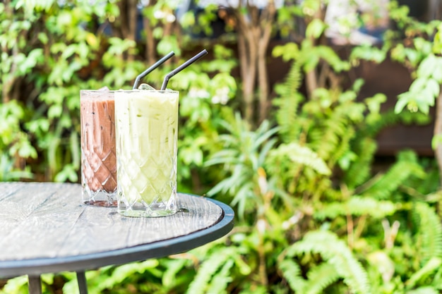 chá verde matcha gelado e copo de chocolate em cima da mesa