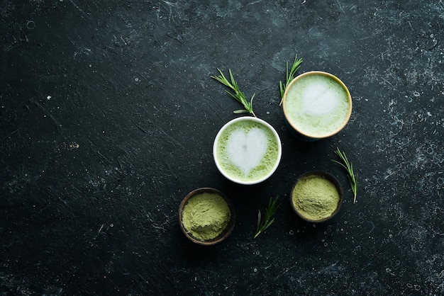 Chá verde matcha latte art em uma xícara sobre fundo de pedra preta Bebidas asiáticas Vista superior