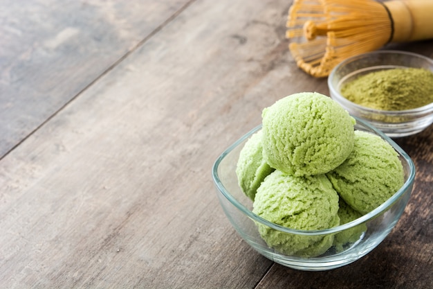 Chá verde matcha sorvete em uma tigela de cristal no espaço da cópia de mesa de madeira