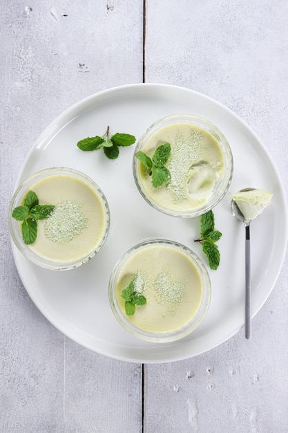 Chá Verde Pana cotta em um copo decorado com folha de hortelã