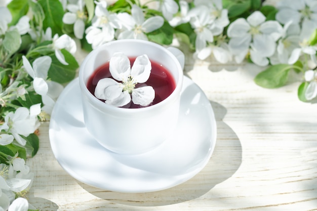 Foto chá vermelho com flor de maçã, luz natural