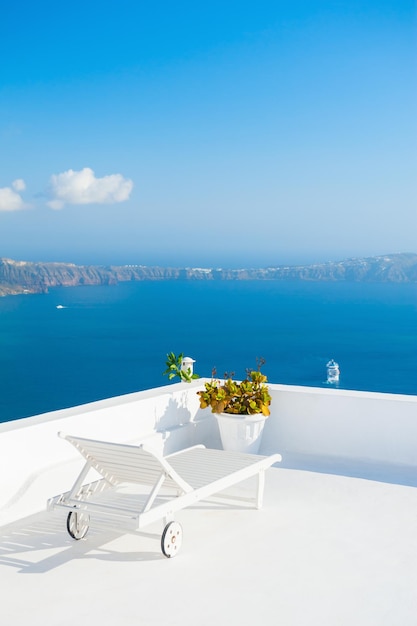 Chaise lounge en la terraza con vista al mar. Isla de Santorini, Grecia.