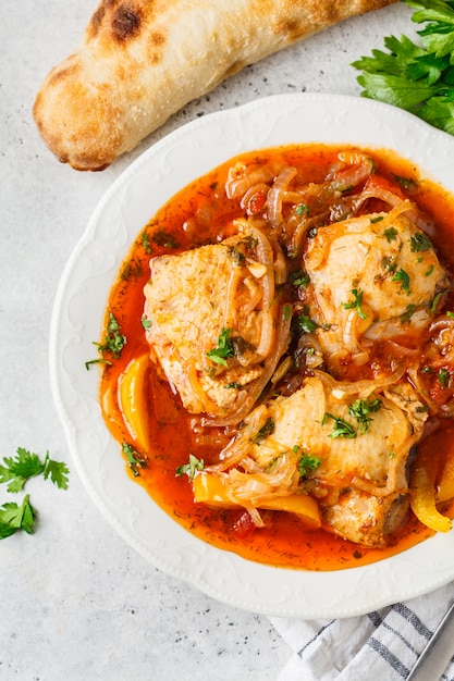 Foto chakhokhbili de pollo tradicional georgiano en un plato blanco.