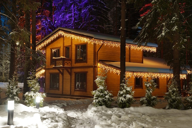 Chalé de madeira com decorações de Natal em um inverno nevado.