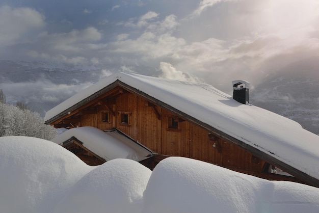 Chalé de madeira em vila alpina coberta de neve fresca em paisagem montanhosa