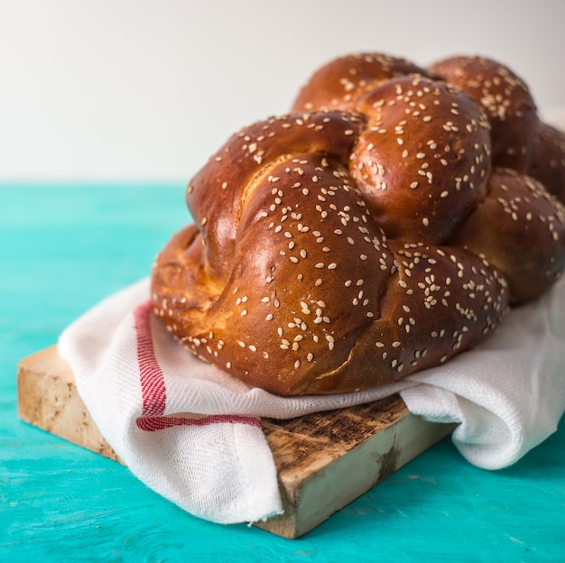 Challah-Brot auf einer hölzernen Platte auf Holztisch