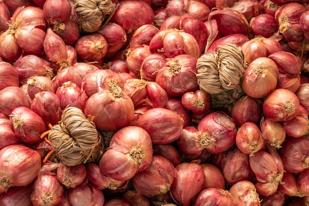 Chalotas ou ervas asiáticas de cebola vermelha e ingredientes de cozinha em fundo de madeira