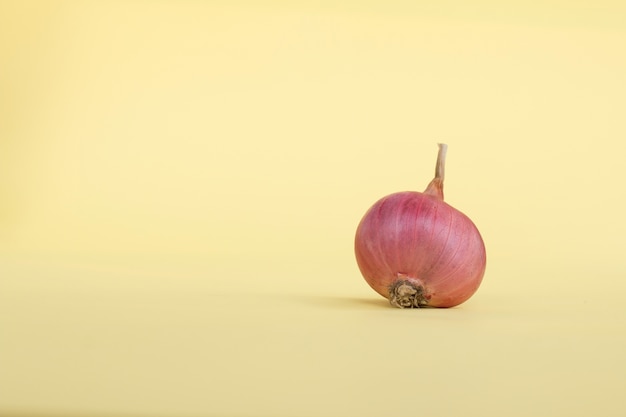 Foto los chalotes en el fondo de papel vintage, objetos de alimentos en el fondo de color pastel