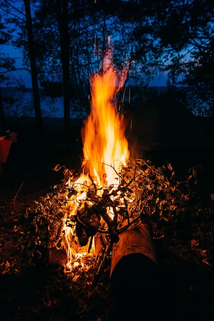 Chama de fogo à noite no escuro nas férias de verão