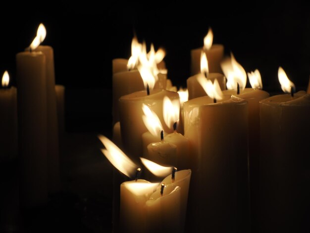 Chama de velas em um túmulo Dia de Todos os Santos Vela votiva em um fundo preto escuro O Dia dos Mortos