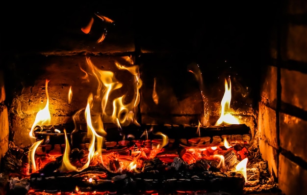 Chamas de fogo e brasas de madeira queimada na lareira