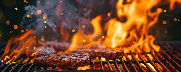 Chamas grelhando suculentos e deliciosos bifes de carne na churrasqueira