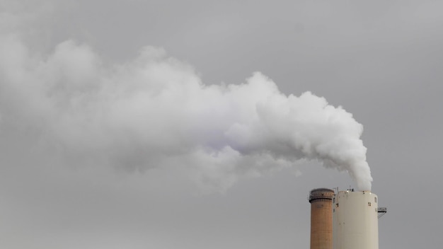 Foto chaminé industrial com gases e fumaça a sair - conceito: poluição atmosférica