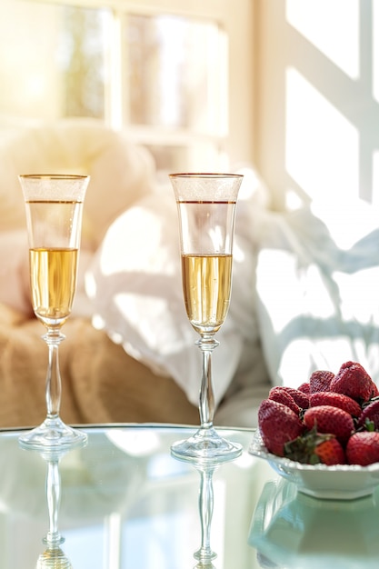 Champagne in den Gläsern und in den Erdbeeren auf einer weißen Platte