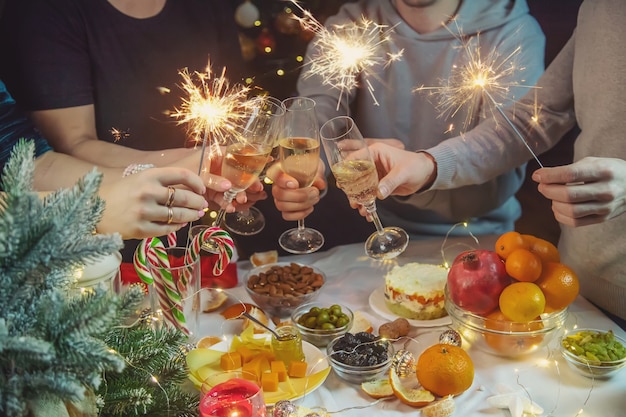 Champagner in der Hand gegen den Weihnachtsbaum