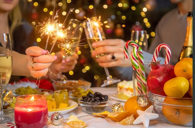 Champagner in der Hand gegen den Weihnachtsbaum