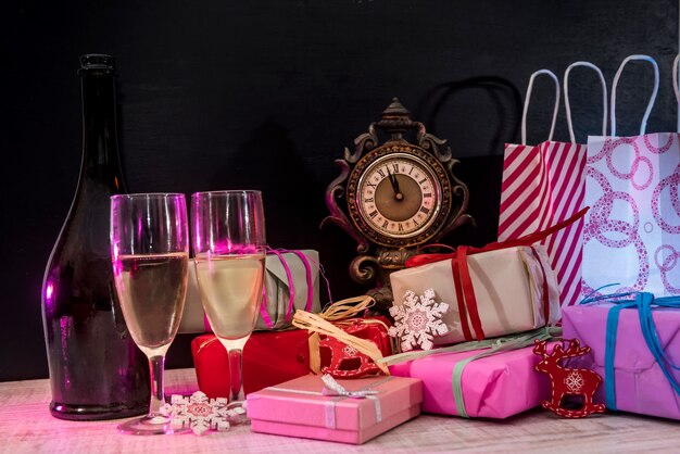 Champagner in Gläsern auf Holztisch mit bunten Weihnachtsgeschenken