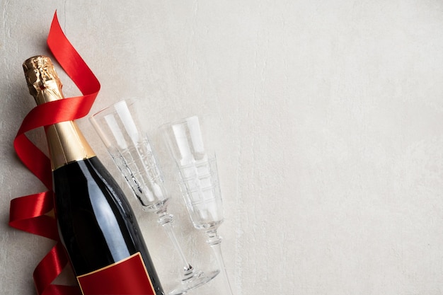 Champagner Valentinstag, Geburtstag, Hochzeit, Jubiläum, Frauentag, 8. März. Sektflasche und zwei leere Gläser auf hellem Steinhintergrund.