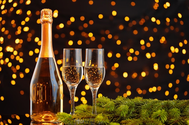 Champagnerflasche und Gläser auf verschwommenen Lichtern