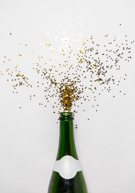 Champagnerflasche und goldene Glitzer auf Weiß