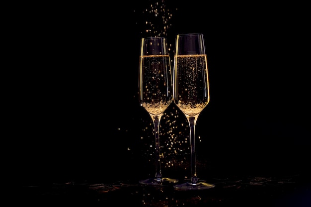 Champagnergläser mit schwarzem Hintergrund und Lichtern