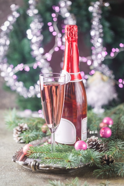 Champán rosa en una copa y adornos navideños