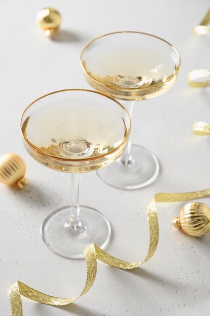 Champanhe de ano novo festivo e enfeites de ouro de Natal em fundo branco