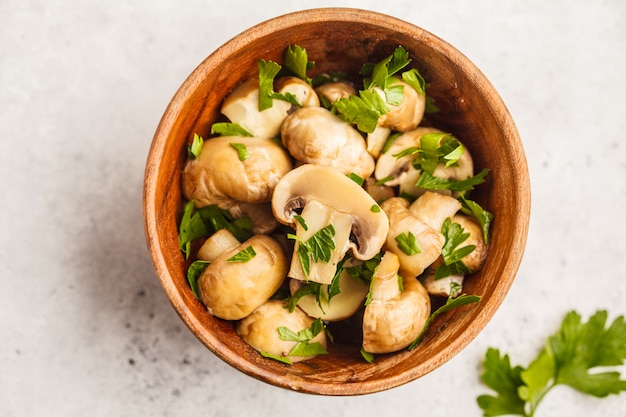 Champignon assado com salsa em uma tigela de madeira.