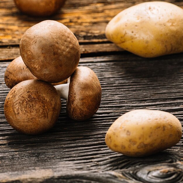 Champignon de cogumelos marrons frescos prontos para cozinhar em uma velha mesa de madeira